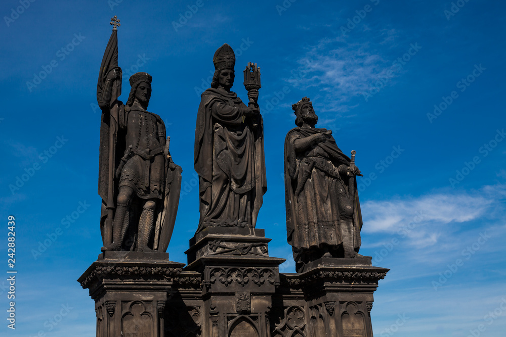 Antique statue of Saints Norbert of Xanten, Wenceslas and Sigismund on the medieval gothic Charles Bridge in Prague built on the 15th century Antique statue of Saints Norbert of Xanten, Wenceslas and Sigismund on the medieval gothic Charles Bridge in Prague built on the 15th century