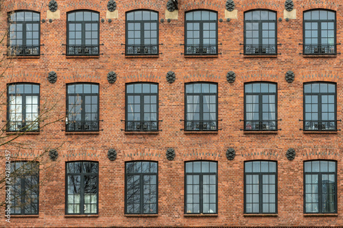 Żyrardów, Poland. Window with iron frame and red bricks wall of old factory.