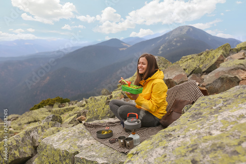 Wallpaper Mural Young woman in yellow jacket have a picnic on top of the mountain.  Torontodigital.ca