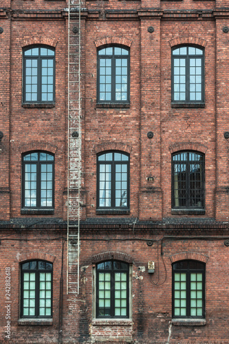Żyrardów, Poland. Window with iron frame and red bricks wall of old factory.