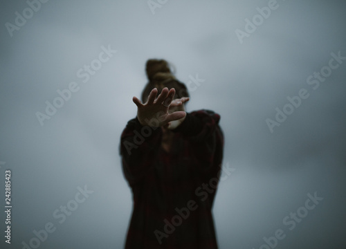 woman's hands in the clouds moody and dark