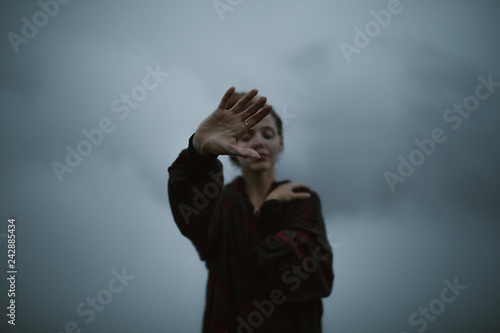 woman's hands in the clouds moody and dark