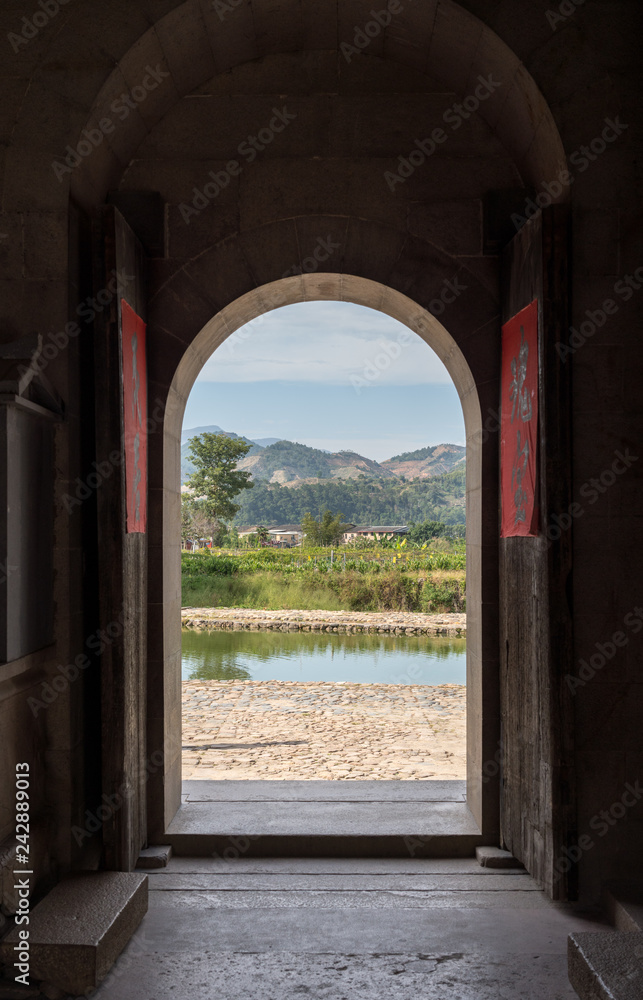 Wooden doorway exit to pond at Tulou at Unesco heritage site near Xiamen