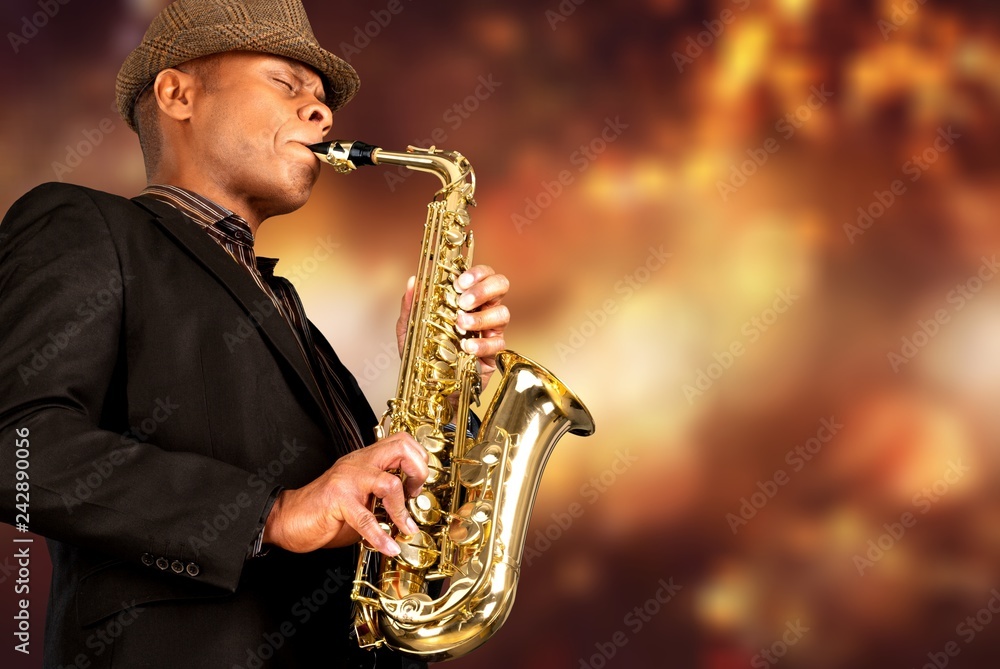 Fototapeta premium Close-up man playing on saxophone on blurred background