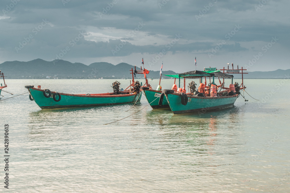 Fototapeta premium Blue wooden fishing boats in calm tropical turquoise water near Rabbit Island in Cambodia