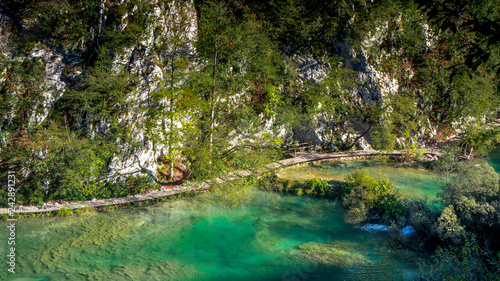 Fototapeta Naklejka Na Ścianę i Meble -  Path along a Lake within the colorful Plitvice National Park in Croatia