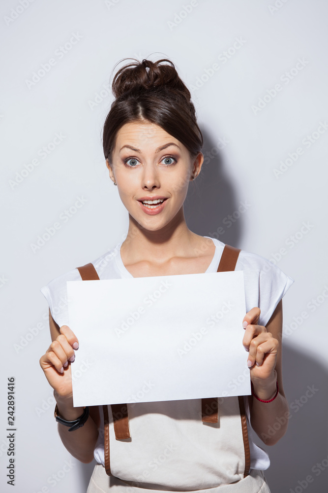 Smiling young pretty woman showing blank signboard, over white background isolated. Smiling young pretty woman showing blank signboard, over white background isolated.