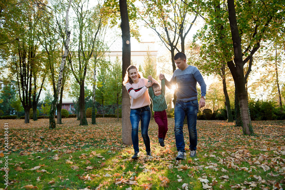 Family of three enjoy autumn park having fun smile