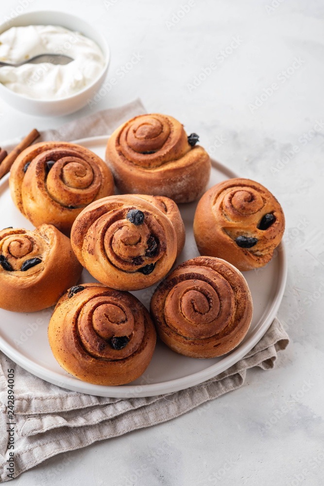 Freshly Baked Traditional Sweet Cinnamon Rolls, Swirl on white plate. Copy space.