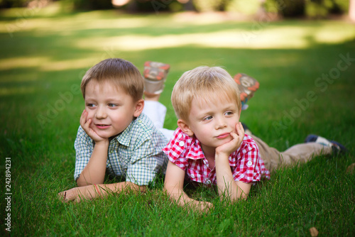 Two young boys walk and relax in the park.