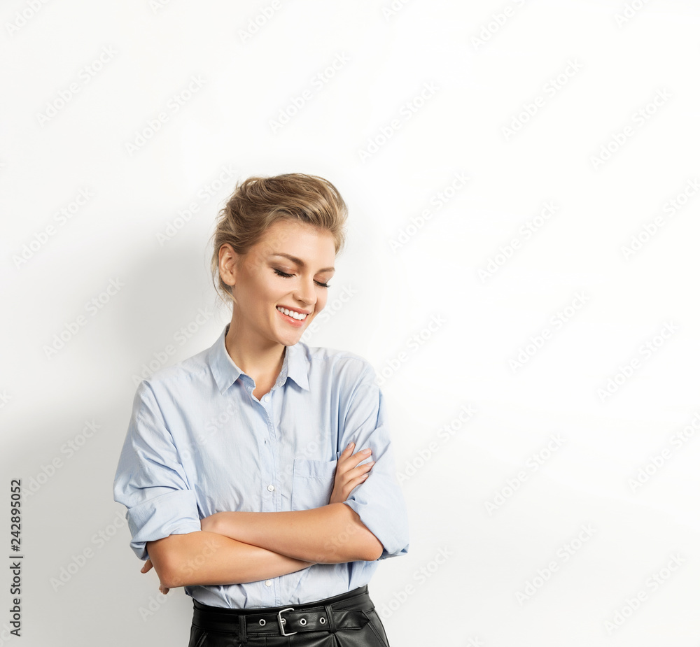 Portrait of stylish blonde female wearing trendy clothes. Beautiful smiling model posing on white background. Sweet girl with natural makeup. Youth and happiness concept Portrait of stylish blonde female wearing trendy clothes. Beautiful smiling model posing on white background. Sweet girl with natural makeup. Youth and happiness concept