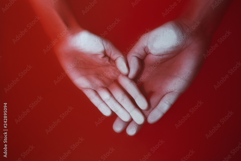 hands of a man and a woman in the shape of a heart sinking in red water, concept of love and feelings hands of a man and a woman in the shape of a heart sinking in red water, concept of love and feelings