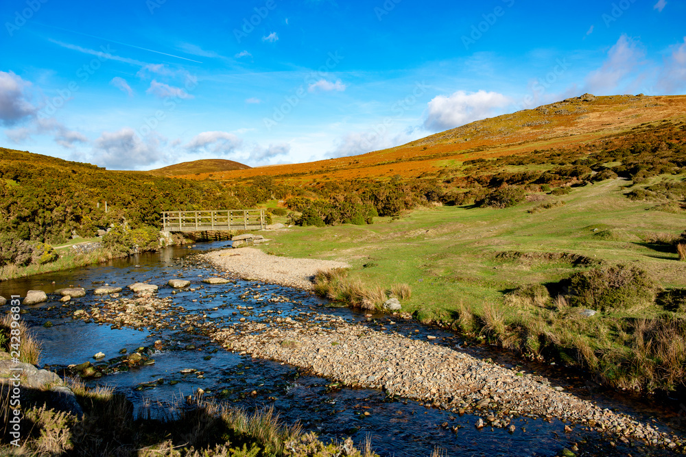 Stepping stones and wooden bridge cross the River Lyd on Dartmoor