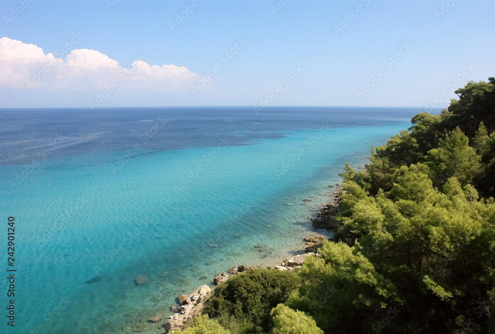 Panoramic view from the hill on the coast with the crystal clear sea of turquoise color in Greece.