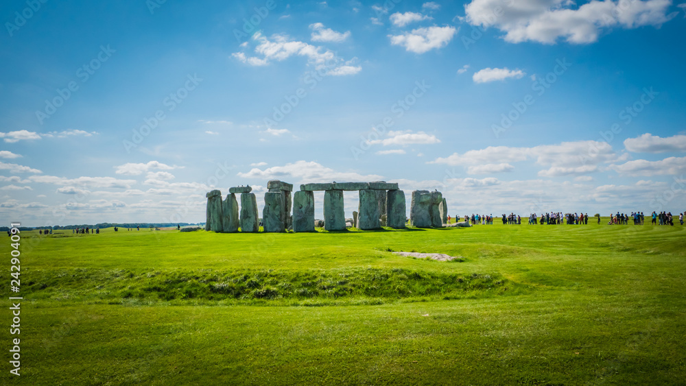 Stonehenge unesco world heritage site on sunny day, Salisbury in England. Summer holidays destination in the UK, Europe. Green countryside landscape with blue sky on a summer day in Great Britain.