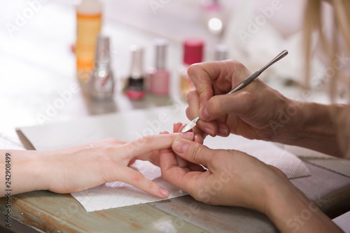 Manicure process. Woman works on younger girl's hands and nails. Close-up.