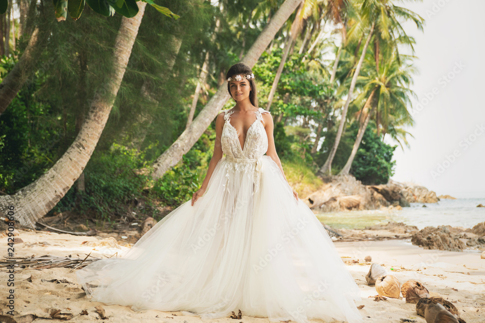 Sensual bride wearing beautiful wedding dress on the tropical island