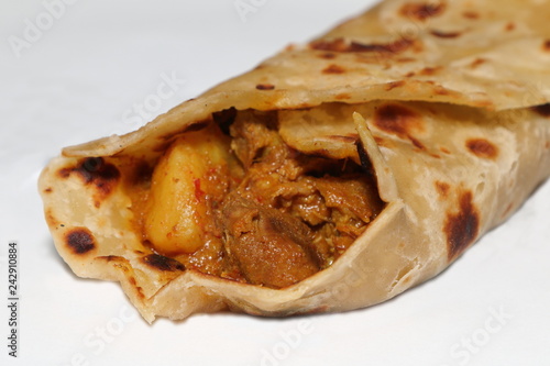 Close-up of a lamb roti roll - an Indian bread with lamb curry as a filling, a popular Indian dish / takeaway food in South Africa. (Shallow depth of field effect)