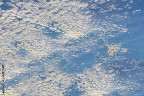 The vast blue sky and clouds lies above surface Earth atmosphere