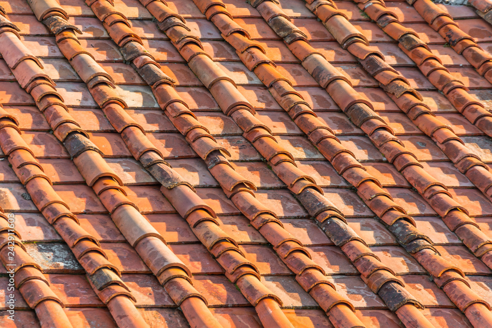 Fototapeta premium Ceramic orange clay tiles on the roof of a building.
