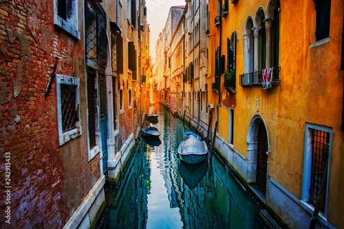 Sunset at canal Venice with clear sea water and boats.
