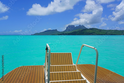 Jumping from the stairs of a boat onto the bright turquoise azure blue lagoon of Bora Bora in French Polynesia