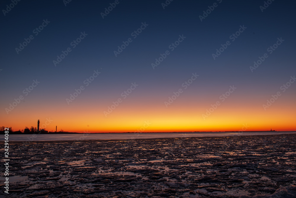 dramatic red sunset over the frozen sea on the beach