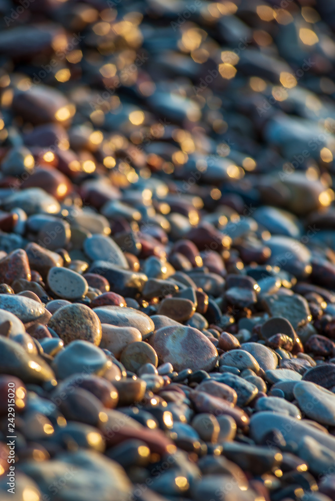 Obraz premium abstract details of rocky beach pebbles in sunset by the sea