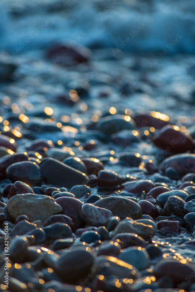 Obraz premium abstract details of rocky beach pebbles in sunset by the sea