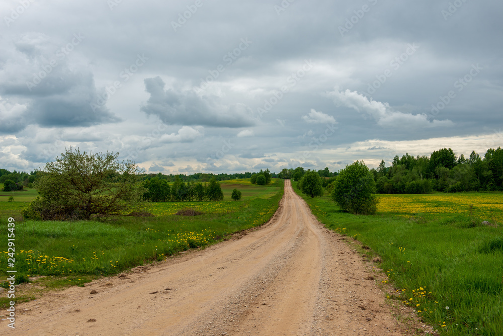 country gravel road with old and broken asphalt