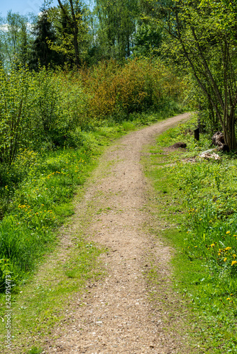 country gravel road with old and broken asphalt