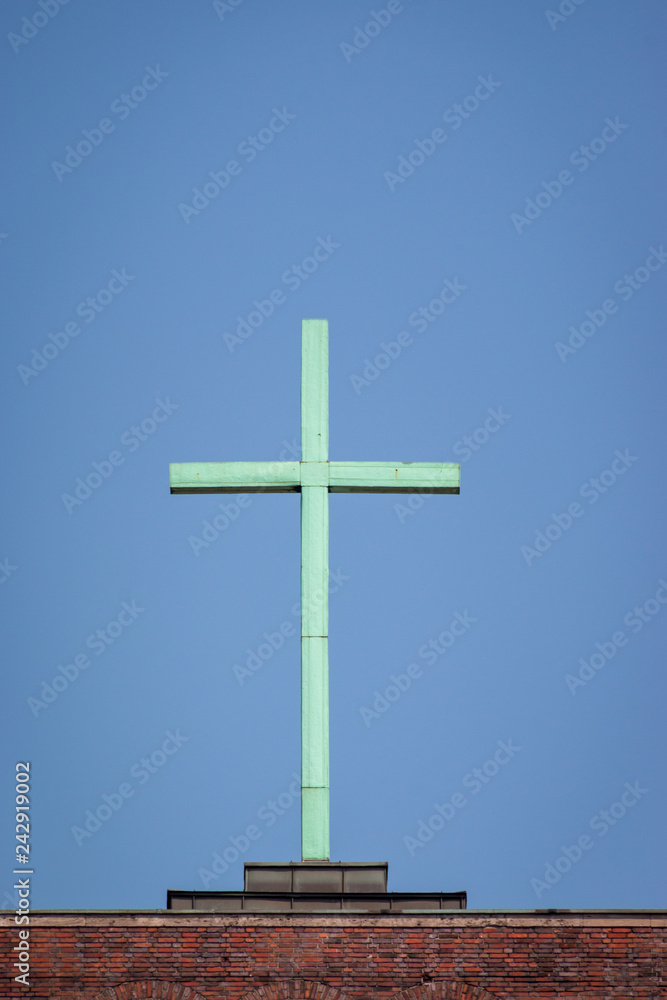 Cross on top of a church in front of a blue sky