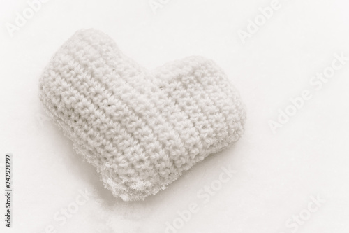Pink knitted heart on the snow