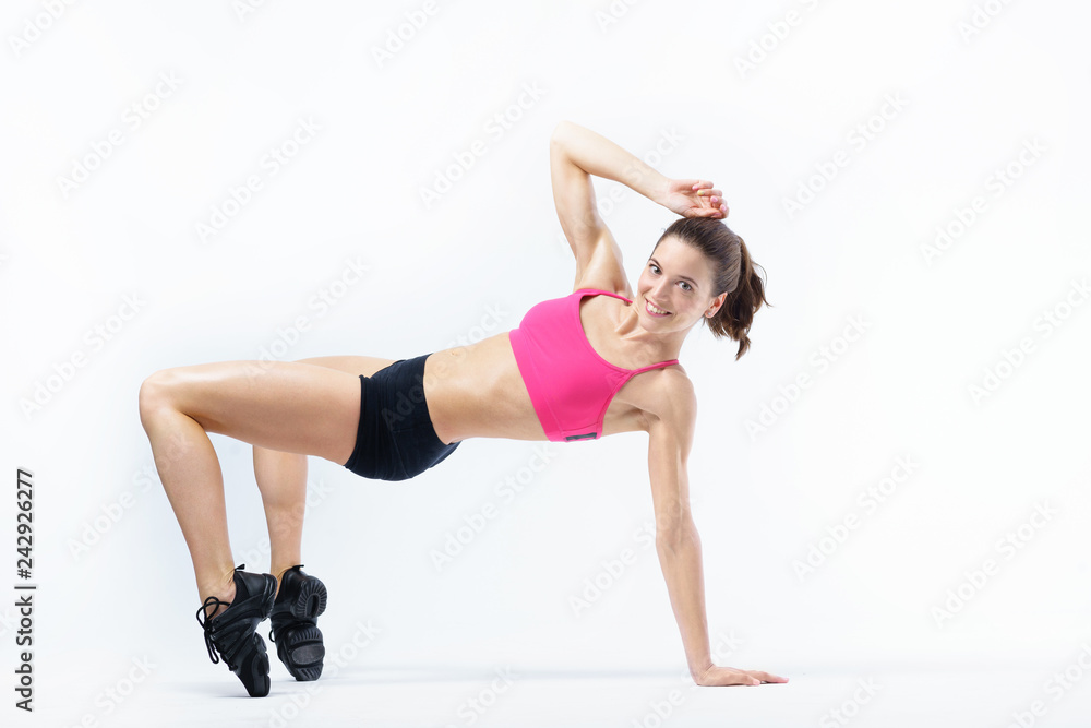 Obraz premium Young attractive tanned slender girl performs sports exercises.