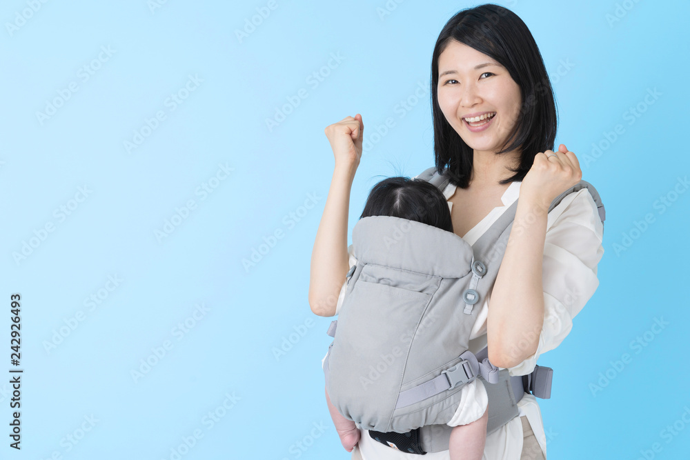 portrait of young asian mother and baby on blue background portrait of young asian mother and baby on blue background