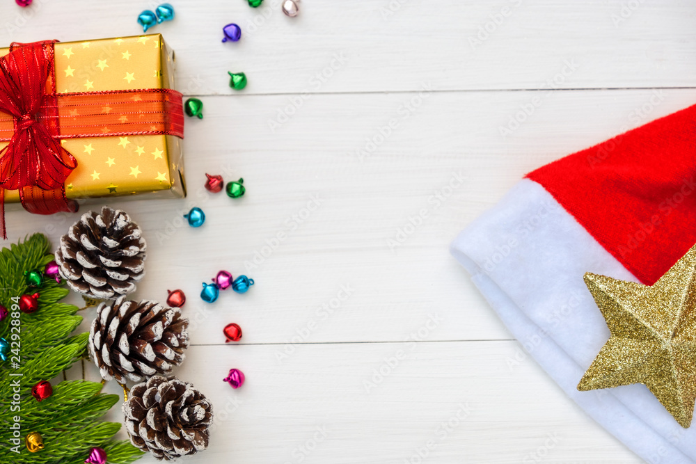 Obraz premium Christmas and Happy new year composition, Christmas present gift boxes,pine cones, fir branches, red christmas hat , golden star on wooden white background. Flat lay, top view, copy space.