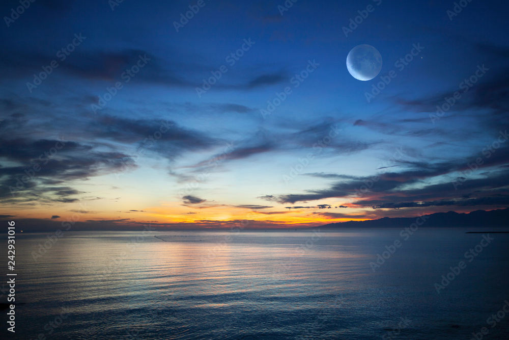 夜明けの海と朝焼けに染まる空の月 Stock Photo Adobe Stock