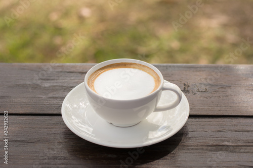 Coffee espresso on wood table nature background in garden warm tone