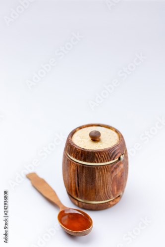 Isolated barrel and spoon with honey on a white background.