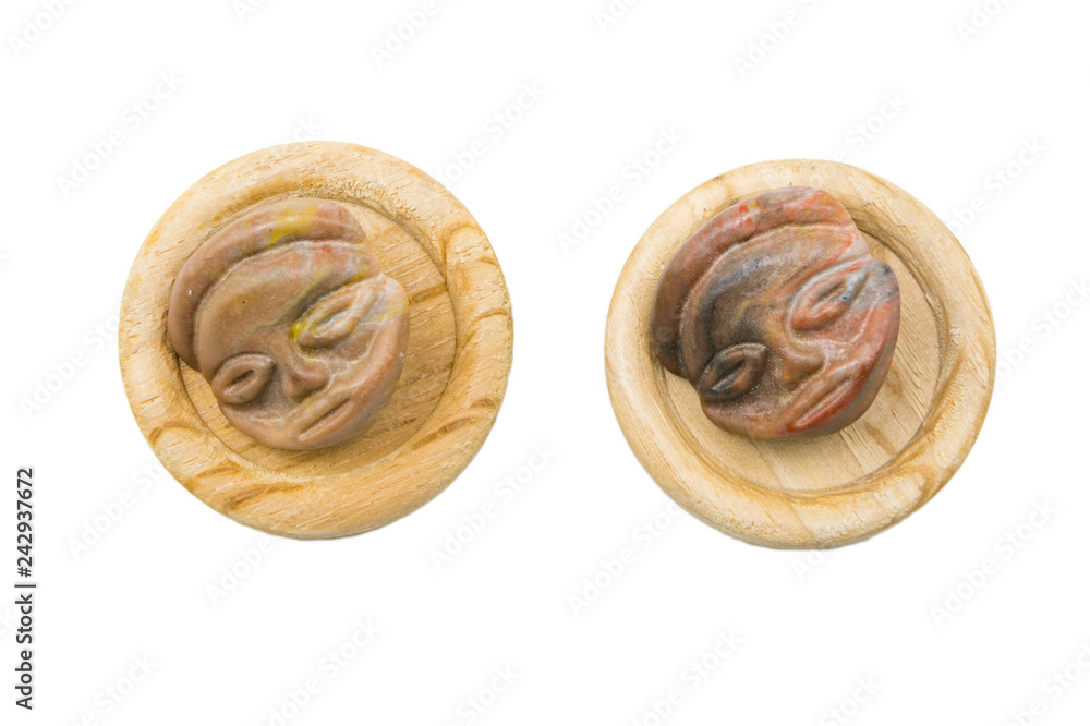 Wood sewing buttons bone buttons with the face of an alien on an isolated background 