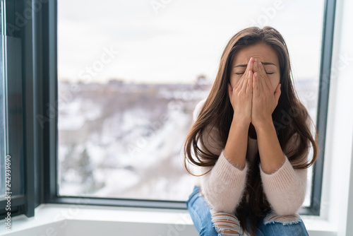 Anxiety winter depression woman having a panic attack and a hard time breathing. Home alone girl crying stressed depressed. photo