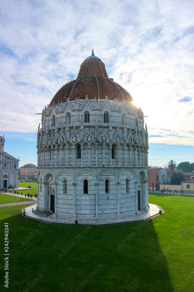 Amazing view to Pisa baptistery and piazza dei miracoli (square of miracles) in a sunny winter day, Tuscany, Italy