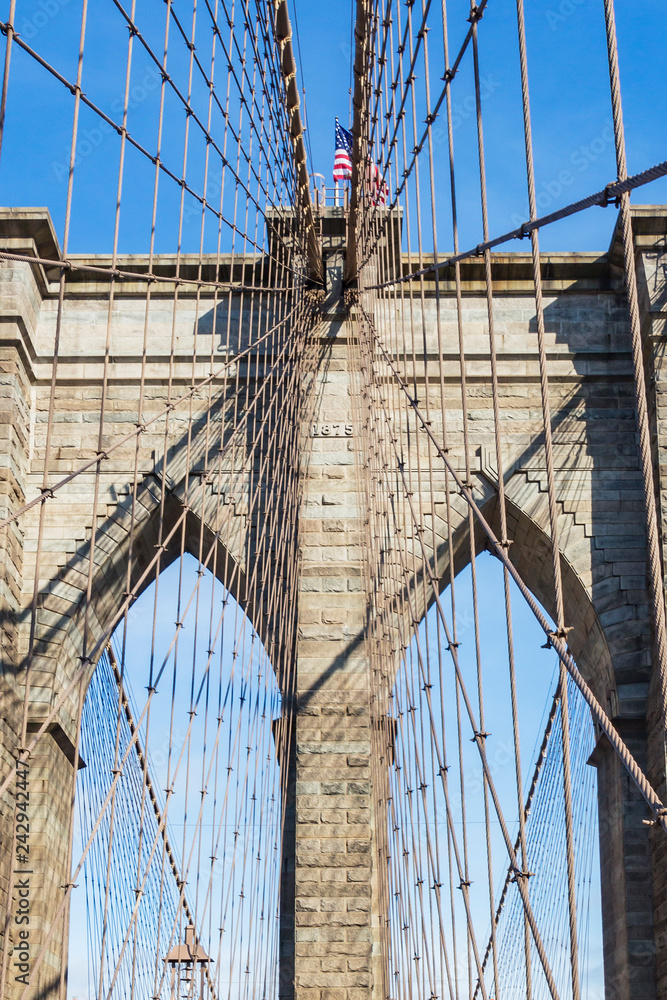 Obraz premium Szczegóły wież ze stalowymi kablami mostu Brooklyn w Nowym Jorku, Stany Zjednoczone