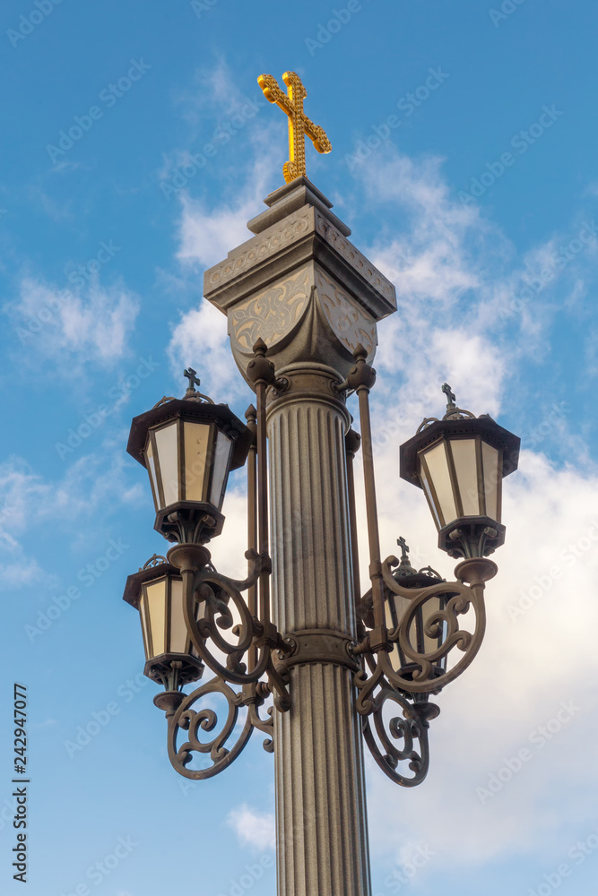 Street light with a golden cross on the top in Moscow city center