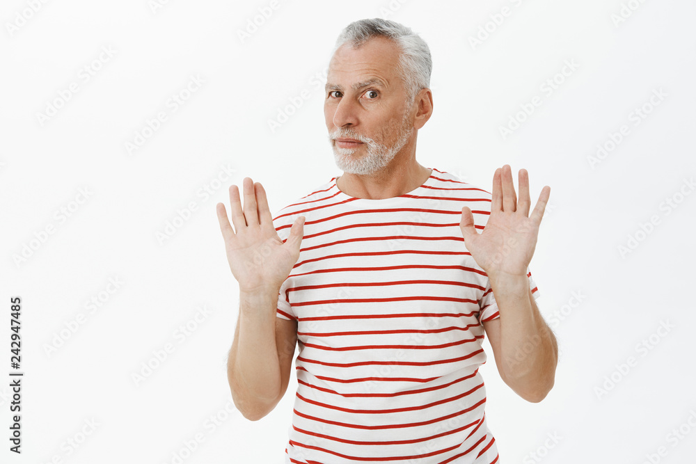 Relax and chil I got it. Portrait of intense questioned charismatic mature man with grey hair and beard raising palms in surrender rejecting offer being uninvolved trying act innocent over white wall Relax and chil I got it. Portrait of intense questioned charismatic mature man with grey hair and beard raising palms in surrender rejecting offer being uninvolved trying act innocent over white wall