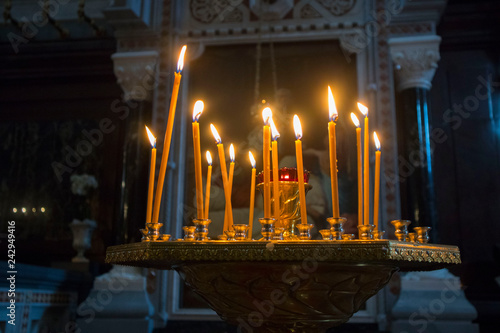 Many burning wax candles in the orthodox church or temple
