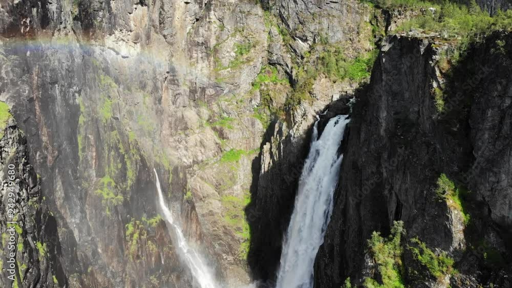 Voringsfossen waterfall with rainbow in summer, Mabodalen valley Norway. National tourist Hardangervidda route, touristroad 7, Eidfjord sightseeing tour Voringsfossen waterfall with rainbow in summer, Mabodalen valley Norway. National tourist Hardangervidda route, touristroad 7, Eidfjord sightseeing tour