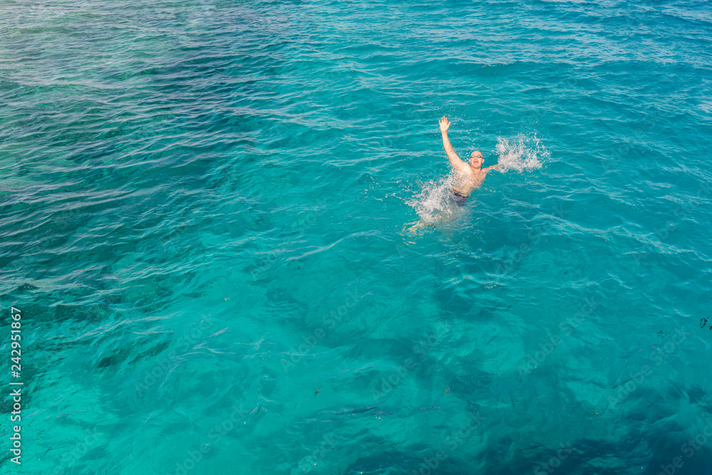 Drowning man in sea asking for help with raised arms. The man is drowning in the sea. man drowning in the sea and waving hand for help.