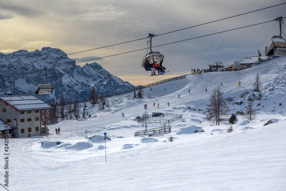 ski slopes with skiers and chairlift at sunset. Trentino, Italy ski slopes with skiers and chairlift at sunset. Trentino, Italy