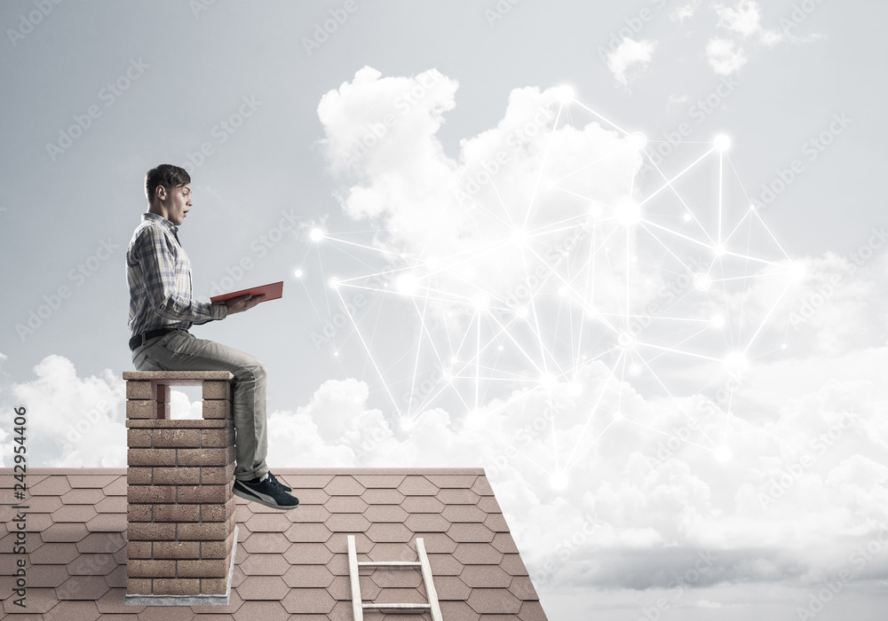 Man on brick roof reading book and concept of social connection Man on brick roof reading book and concept of social connection